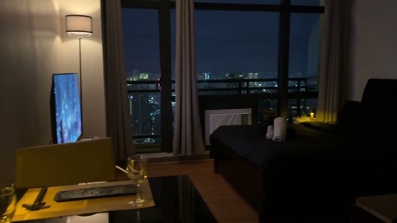 The Solstice suite at dusk, with the Makati skyline beyond the balcony.
